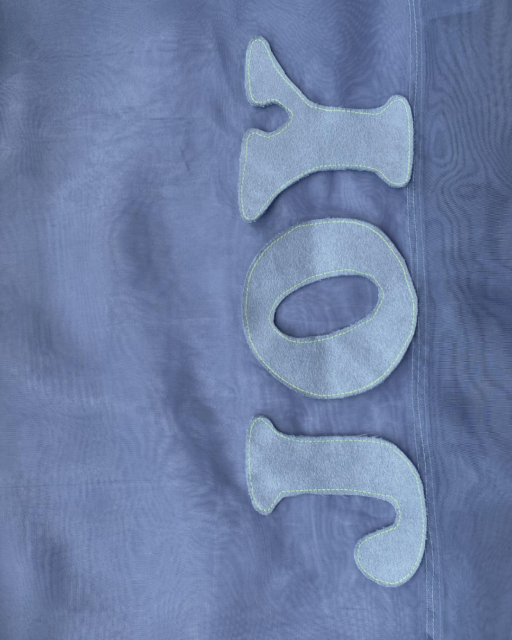 letters JOY sewn on tote bag