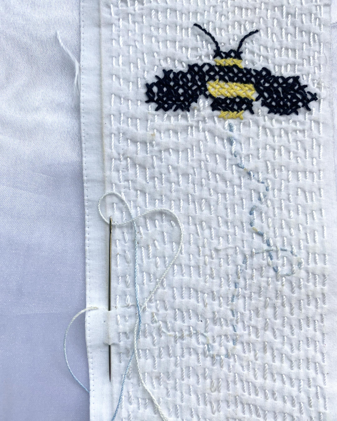 cross stitch bee on white running stitches