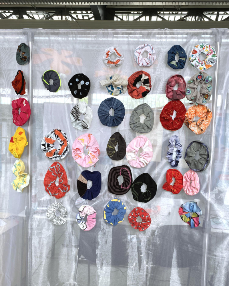 42 scrunchies hanging on a white curtain
