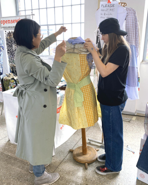 2 young women working on a colourful dress on the mannequin