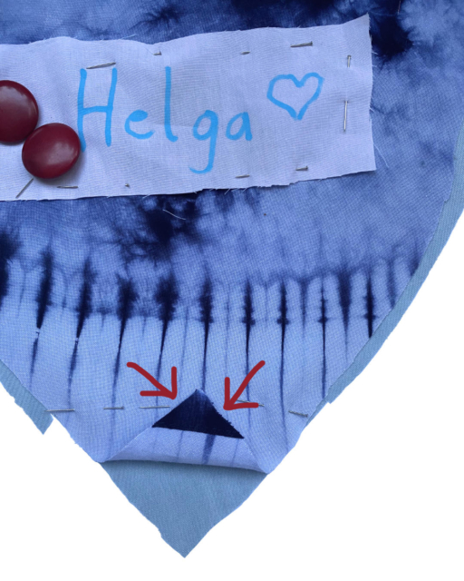 batik heart with tucked white patch "Helga" and two arrows pointing to triangle
