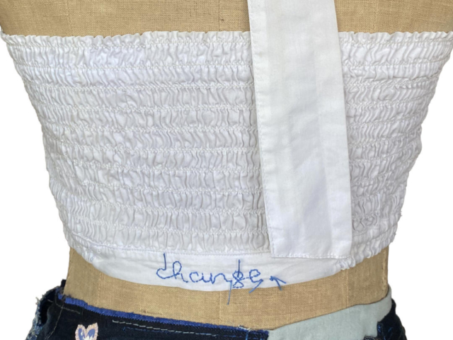 detail of embroidered change on white top